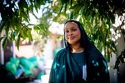 Ahlam Osman stands by a persimmon tree at her home in Northeast Portland in October 2023. Osman has been working to develop more environmental leaders in Portland’s African Muslim youth community. She says the Quran and Islam encourage environmental stewardship and caring for the planet.