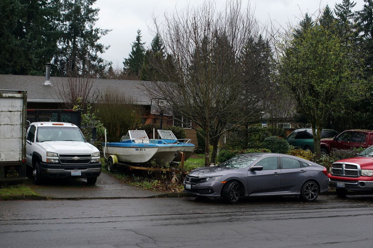 Vehicles are parked around a single-story house