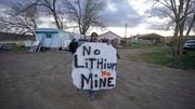 Kess Hinkey, a Paiute-Shoshone tribal member holds a large hand-painted sign "No Lithium No mine" on April 24, 2023, on the Fort McDermitt Indian Reservation, near McDermitt, Nev. The Biden administration says the project will help mitigate climate change by speeding the shift from fossil fuels. But opponents say it is not worth the costs to the local environment and people. (AP Photo/Rick Bowmer)