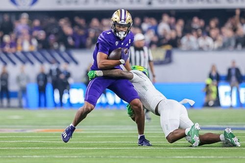 An Oregon defender (right) tries to tackle Washington receiver Rome Odunze (1) as the No. 5 Ducks take on the No. 3 Huskies in the Pac-12 championship game on Friday, Dec. 1, 2023, at Allegiant Stadium in Las Vegas.